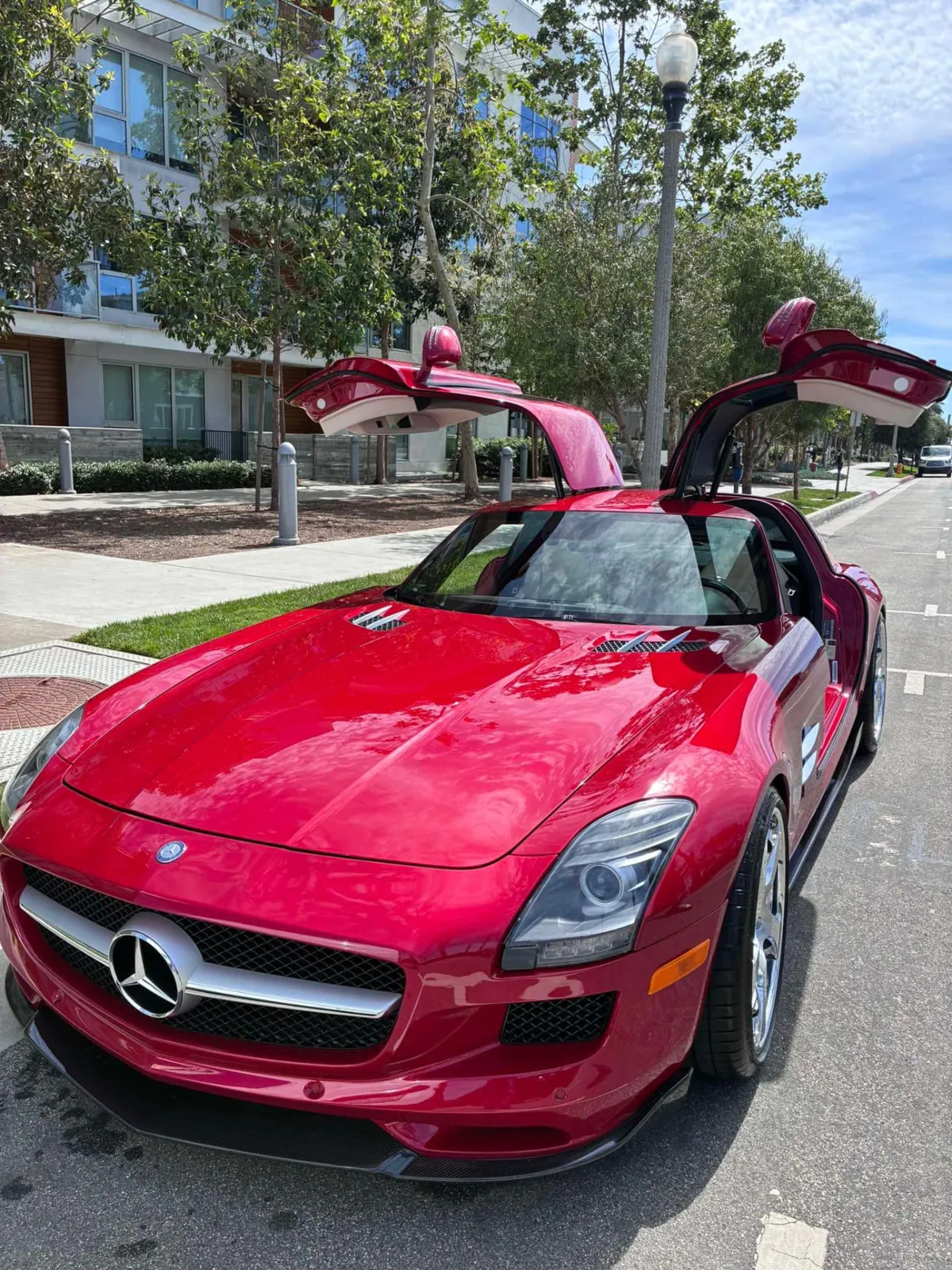 Red Mercedes SLS AMG with gullwing doors open after an elite exterior detail
